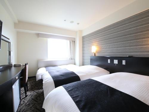 a hotel room with three beds and a window at APA Hotel & Resort Tokyo Bay Makuhari in Chiba