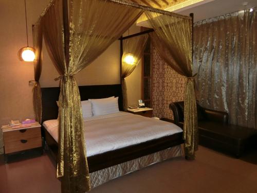 a bedroom with a canopy bed with curtains at Mambo Impression Motel in Chaozhou