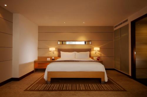 a bedroom with a large white bed and a window at PARKROYAL Saigon in Ho Chi Minh City
