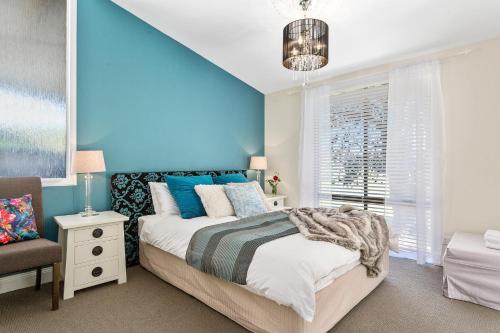 1 dormitorio con paredes azules, 1 cama y 1 silla en Birch Lane, en Cradoc