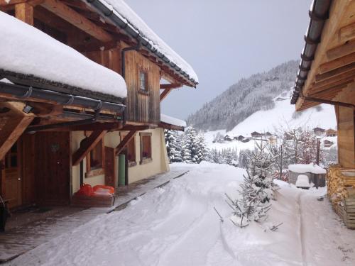 a house with snow on the ground in front of it at La Ferme des Georgières "Séjour en tout compris" in Notre-Dame-de-Bellecombe