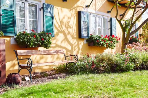 a bench in front of a house with windows at Hotel Garni Schöne Aussichten in Klöch