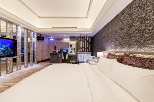 a hotel room with a bed and a tv at Soho Motel in Taoyuan