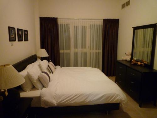 1 dormitorio con cama, tocador y espejo en Townhouse Ras al Khaimah, en Ras al Khaimah