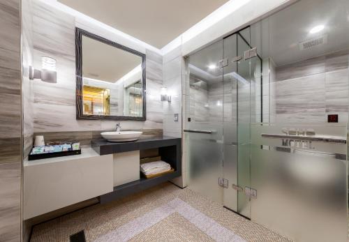 a bathroom with a sink and a glass shower at Soho Motel in Taoyuan