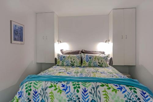 a bedroom with a bed with blue and green sheets at Harbour Heights 2 in Tauranga