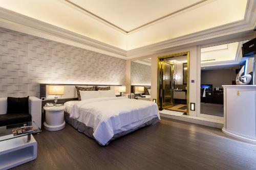 a hotel room with a bed and a television at Soho Motel in Taoyuan