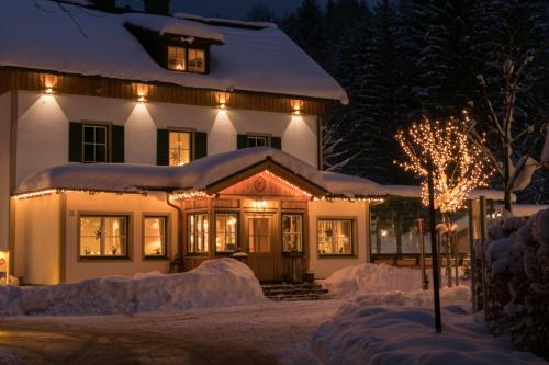 a house covered in snow at night with lights at Waldruhe - Bett, Frühstück & ein Lächeln in Bad Aussee