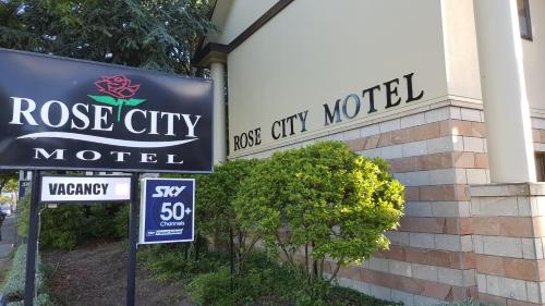 a sign for a rose city motel next to a building at Rose City Motel in Palmerston North