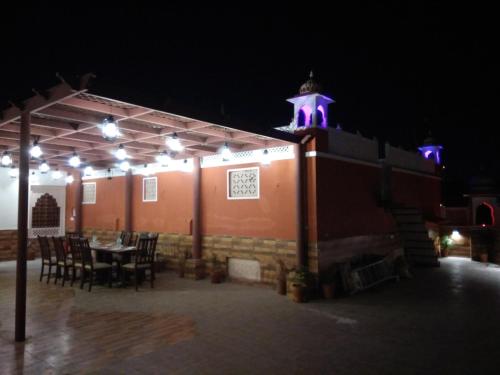 a patio with a table and a building with purple lights at Jaipur Hotel New - Heritage Hotel in Jaipur
