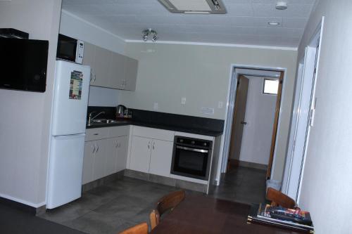 a kitchen with white appliances and a white refrigerator at Rose City Motel in Palmerston North