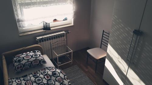 a small bedroom with a bed and a window at Apartment Dominik in Osijek