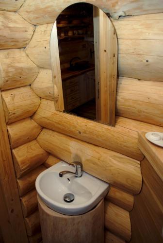 a wooden bathroom with a sink and a mirror at Srub RANCH NA HRANICI in Baška