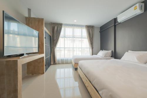 una camera d'albergo con due letti e una TV a schermo piatto di PUNSUK@PRASING a Chiang Mai