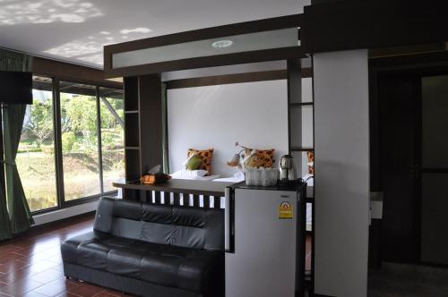 a living room with a refrigerator and a couch at Phumimalee Nature View Resort in Nakhon Ratchasima