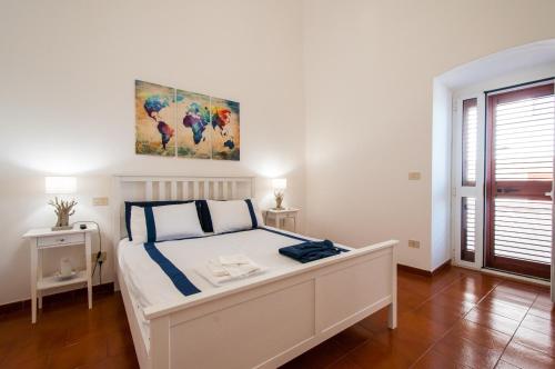 1 dormitorio con 1 cama blanca y una pintura en la pared en Best view Giovinazzo, en Giovinazzo