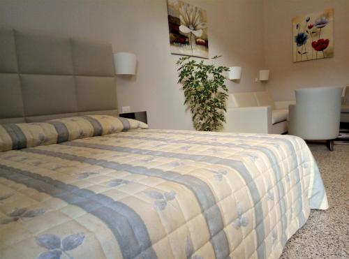 a bedroom with a bed with a blue and white blanket at Hotel Etnea Royal Suites in Catania
