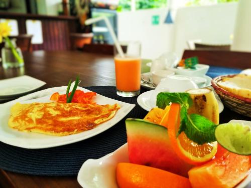 a table topped with plates of food and fruits and vegetables at Unawatuna Nor Lanka Hotel in Unawatuna