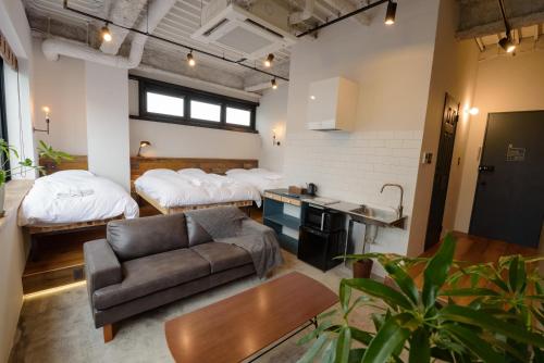 a living room with two beds and a couch at mizuka Imaizumi 1 - unmanned hotel - in Fukuoka