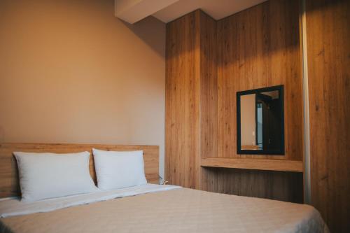 a bedroom with a bed with a mirror on the wall at Hotel Korzo in Bitola
