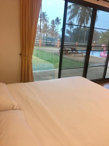 a bedroom with a bed and a view of a pool at Sleep Soundly By The Sea in Trat