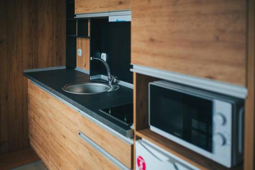 a kitchen with a sink and a microwave at Hotel Korzo in Bitola