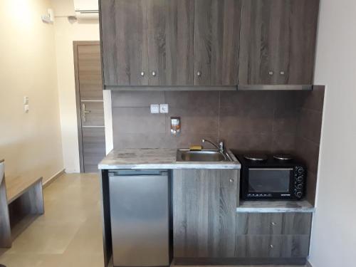 a small kitchen with a sink and a microwave at The Santo George Beach Resort in Amoudara Herakliou