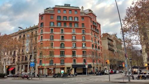 un edificio alto de ladrillo rojo en una calle de la ciudad en Casa Consell Gran Via, Guest House, en Barcelona