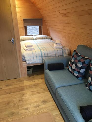 a bedroom with a bed and a couch in a room at Skeabost View Pods Skye in Portree