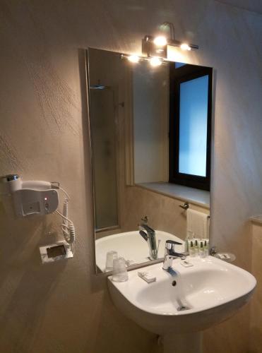 a bathroom with a sink and a mirror at Hotel Etnea Royal Suites in Catania