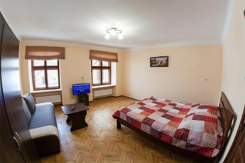 リヴィウにあるКвартира в центрі на вулиці Вірменській 12 є дві спальні двуспальні ліжкаのベッドルーム(ベッド1台、ソファ、テレビ付)