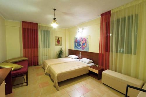a hotel room with a bed and a couch and a bed and a couch at Elimeia 3 Hotel in Aiani