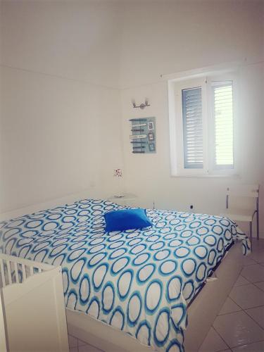 a bedroom with a bed with a blue pillow on it at Casa Giovanna Gioia in Atrani