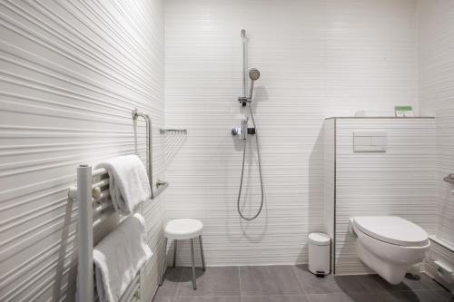 a white bathroom with a shower and a toilet at Prince Albert Montmartre in Paris