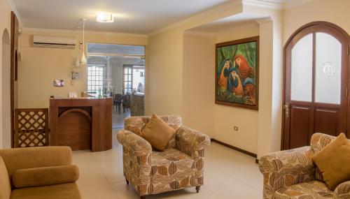 a living room with two chairs and a table at Hotel By Armonía Santa Cruz in Santa Cruz de la Sierra