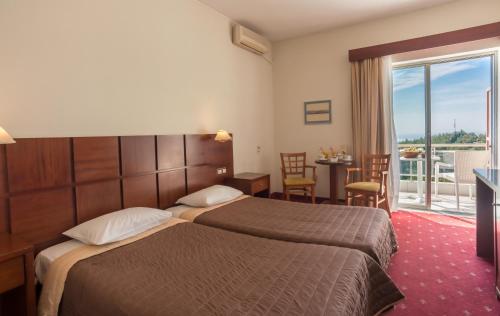 a hotel room with two beds and a balcony at Philippion in Thessaloniki