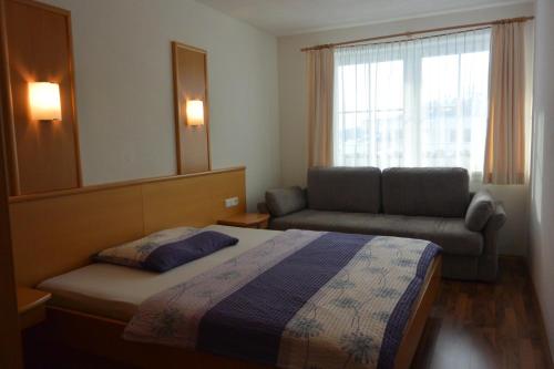 1 dormitorio con cama, sofá y espejo en Appartement Auer en Jerzens