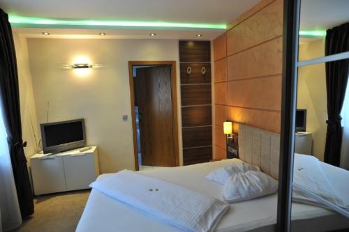 a hotel room with a bed and a television at Hotel Bergischer Hof in Ratingen