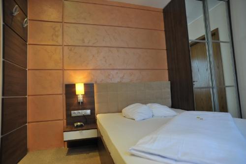 a bedroom with a white bed with a mirror at Hotel Bergischer Hof in Ratingen