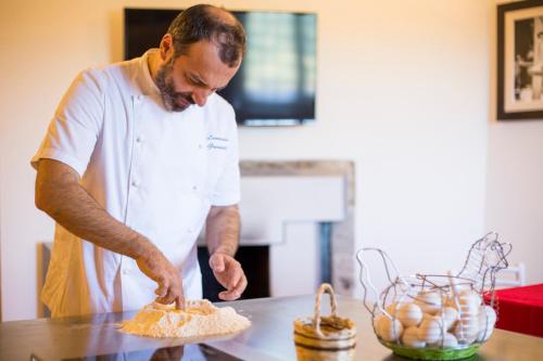 a man standing in a kitchen preparing food at Palazzo Tronconi agriturismo in Arce