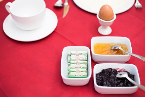 a red table with two containers of food and an egg at Palazzo Tronconi agriturismo in Arce