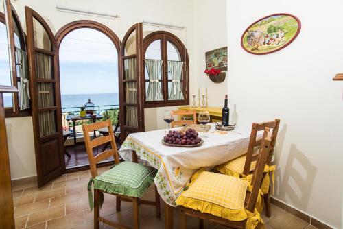 a dining room with a table and chairs with a view of the ocean at Amboula Beach Apartments in Tragaki