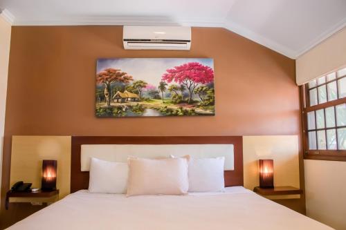 a bedroom with a bed and a painting on the wall at Hotel By Armonía Santa Cruz in Santa Cruz de la Sierra