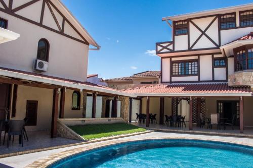 an exterior view of a house with a swimming pool at Hotel By Armonía Santa Cruz in Santa Cruz de la Sierra