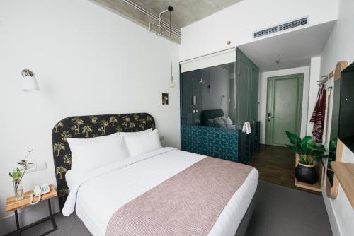 a bedroom with a bed and a room with a mirror at Hotel Monopoli in Jakarta