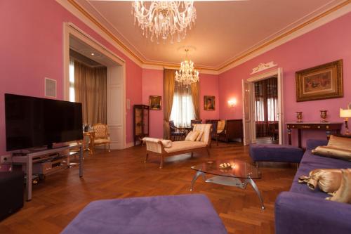a living room with pink walls and a flat screen tv at Filip’s Palace Luxurious Apartment in Ljubljana