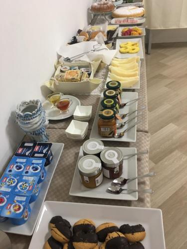 a long table filled with different types of pastries at Alludo Aparthotel b&b in Agrigento