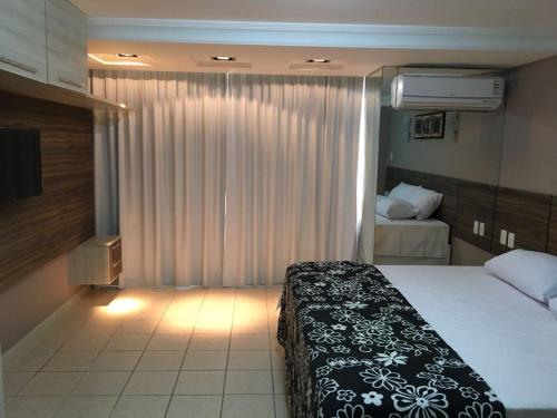 a hotel room with a bed and a window at Atlântico Flat 110 in Natal