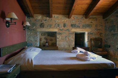a bedroom with a large bed in a stone wall at Pyrgoi Theodorakaki: O Gerolimenas in Gerolimenas