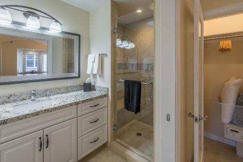 La salle de bains est pourvue d'une douche, d'un lavabo et d'un miroir. dans l'établissement Solvang Alisal Vacation Cottages, à Solvang